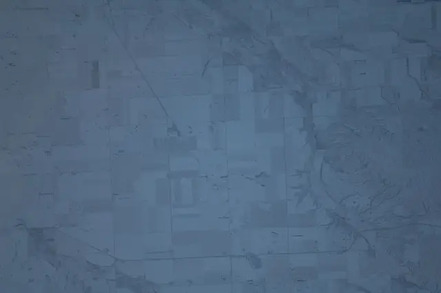 Aerial view of snowy farmland and valley from space